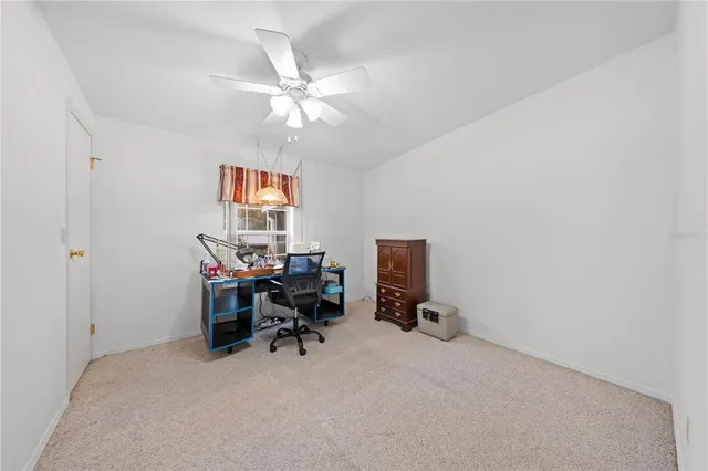 a view of a workspace with furniture and a window