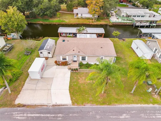 a aerial view of a house with swimming pool and large trees