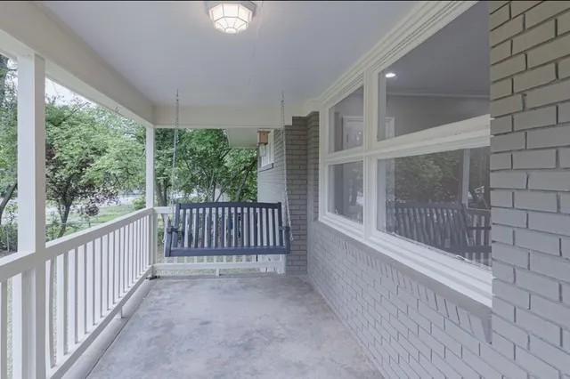 a view of a porch with wooden floor and floor to ceiling window