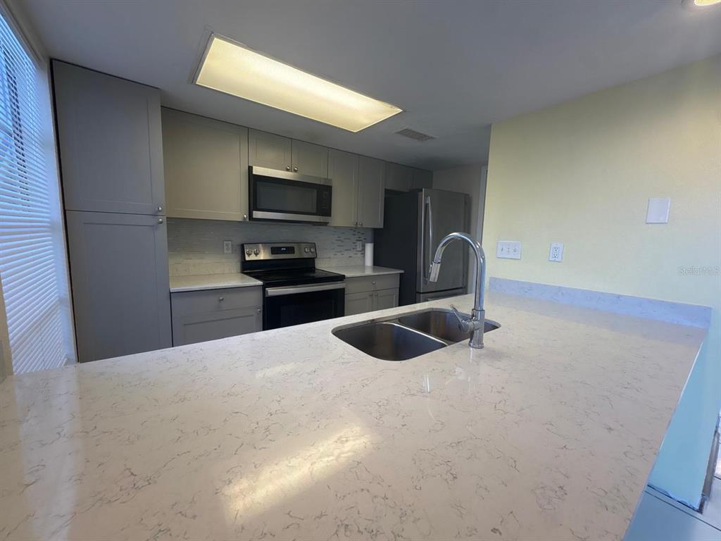 4033 Henley Road, Unit 1707 Orlando, FL 32839 - Photo 42 of 66 a kitchen with granite countertop a sink and a stove top oven