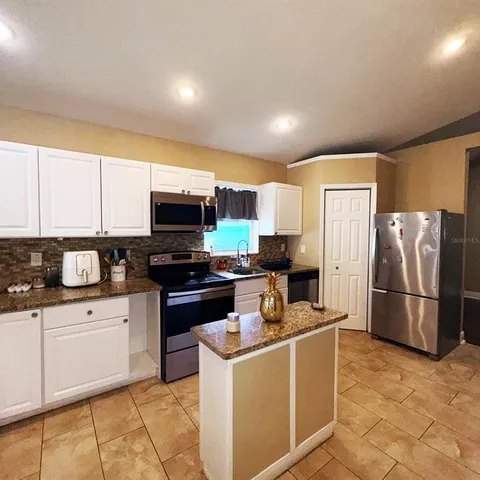a kitchen with a sink stainless steel appliances and cabinets