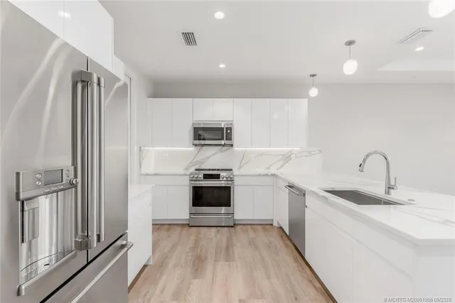 a kitchen with stainless steel appliances a refrigerator sink and stove