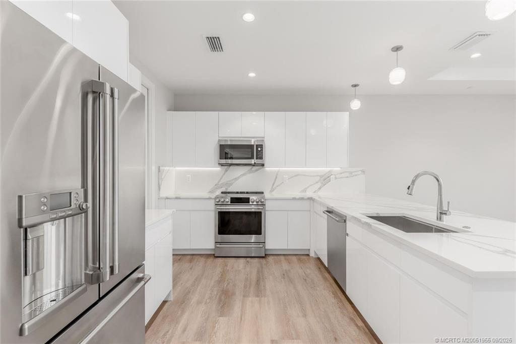 41 Southwest Seminole Street, Unit 203 Stuart, FL 34994 - Photo 10 of 20 a kitchen with stainless steel appliances a refrigerator sink and stove