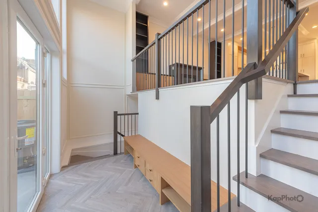 a view of staircase with wooden floor and white walls