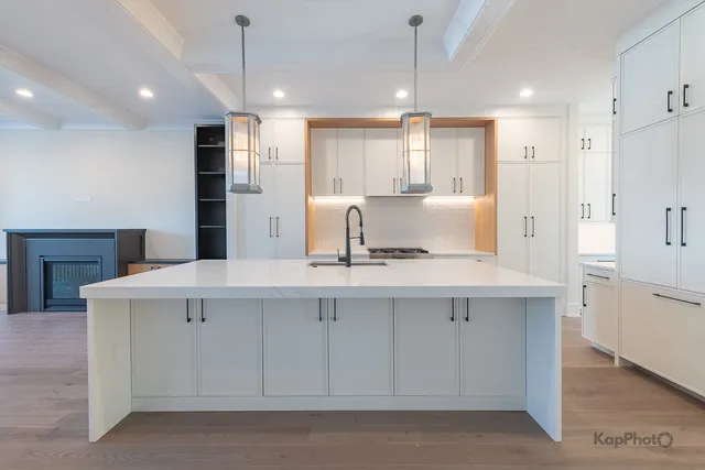 a kitchen with kitchen island white cabinets and refrigerator