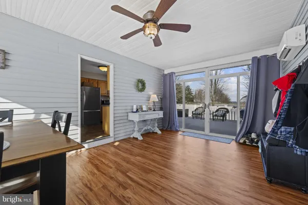a living room with furniture a flat screen tv and a floor to ceiling window