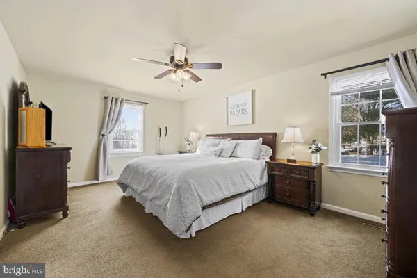 a spacious bedroom with a bed and a dresser