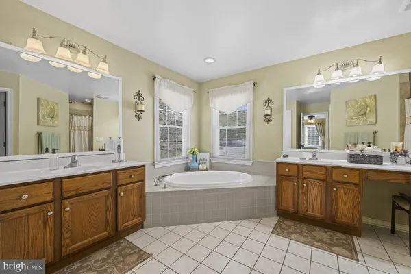 a spacious bathroom with a sink a large mirror and a bathtub