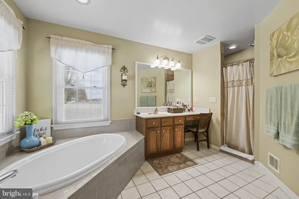 a bathroom with a tub sink and mirror