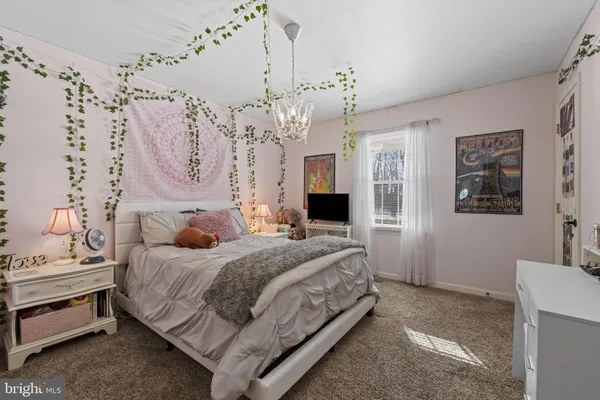 a bedroom with a large bed and a chandelier