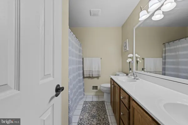 a bathroom with a double vanity sink a toilet and a mirror