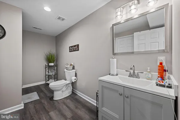a bathroom with a toilet a sink and mirror