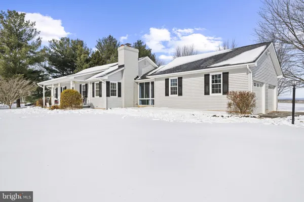 a front view of a house with a yard covered in snow