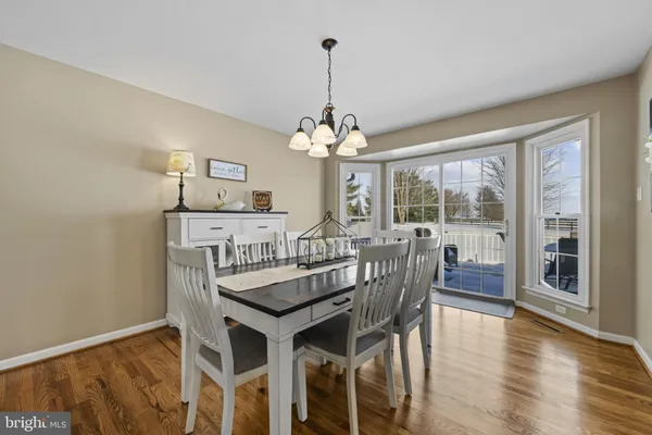 a dining room with furniture window and wooden floor