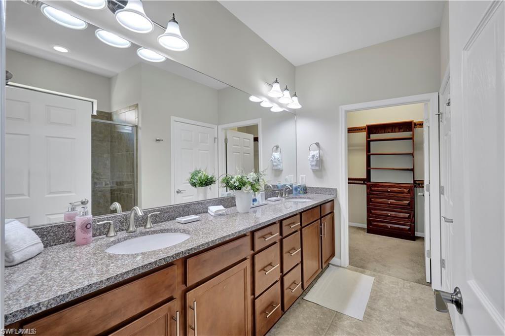 7103 Lily Way Naples, FL 34114 - Photo 20 of 41 a spacious bathroom with a granite countertop sink and a mirror