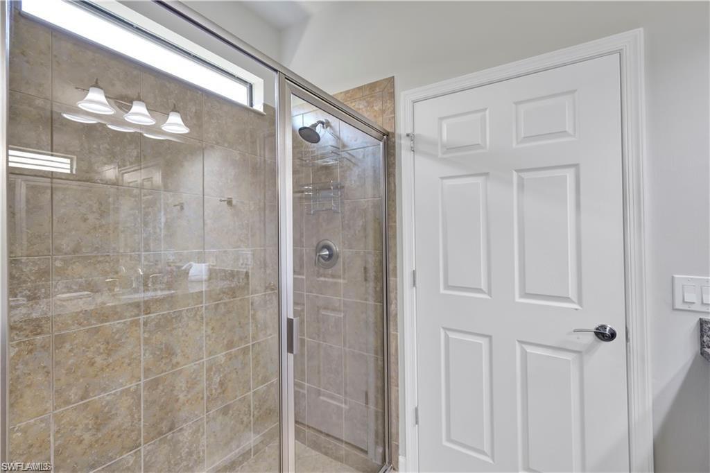 7103 Lily Way Naples, FL 34114 - Photo 21 of 41 a bathroom with a glass shower door and a bathroom