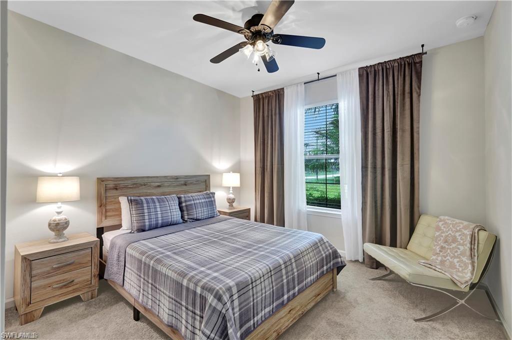 7103 Lily Way Naples, FL 34114 - Photo 26 of 41 a bedroom with a large bed and a chandelier