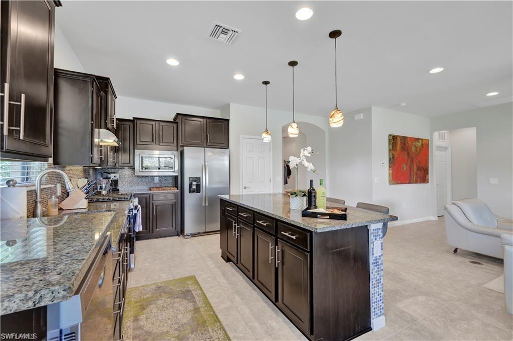 7103 Lily Way Naples, FL 34114 - Photo 3 of 41 a kitchen with stainless steel appliances granite countertop a sink stove and refrigerator