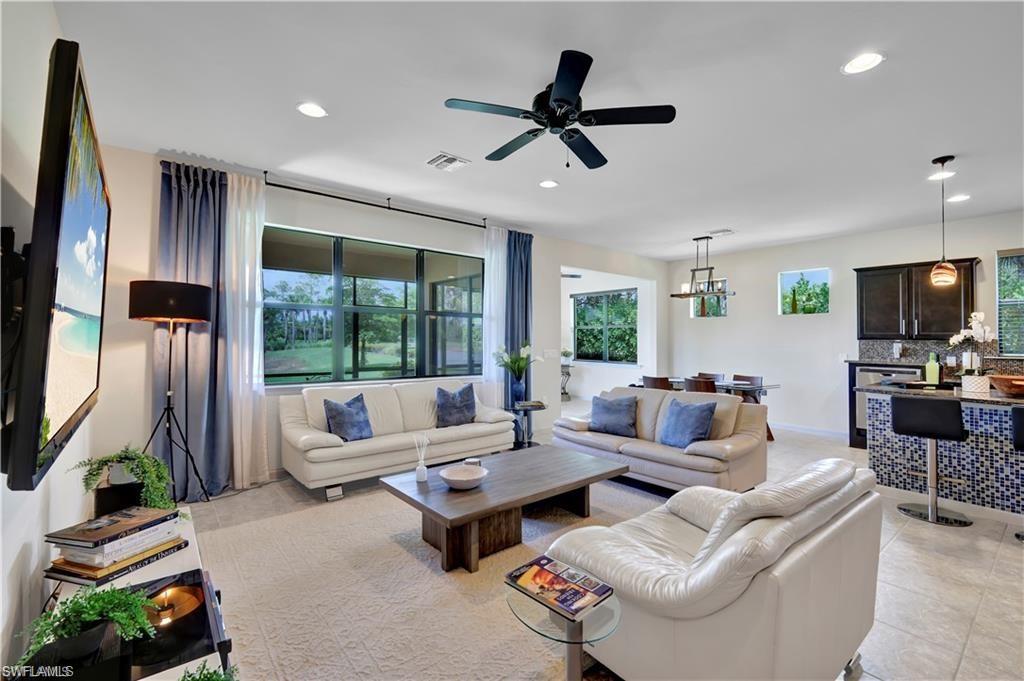 7103 Lily Way Naples, FL 34114 - Photo 10 of 41 a living room with furniture a flat screen tv and a large window