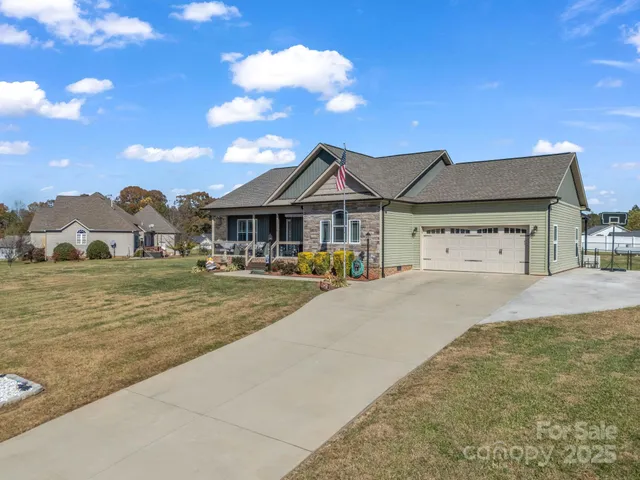a view of a house with a patio and a yard