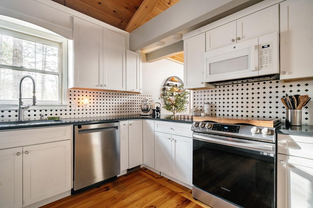 31 Highland Hammock Drive Blue Ridge, GA 30513 - Photo 20 of 67 a kitchen with granite countertop white cabinets and black appliances