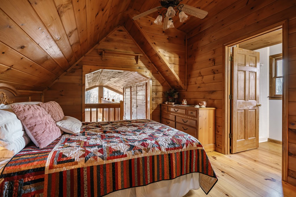 31 Highland Hammock Drive Blue Ridge, GA 30513 - Photo 46 of 67 a bedroom with a bed a mirror on dresser and a large window