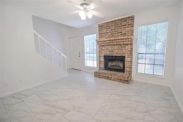 wooden floor fireplace and windows in an empty room