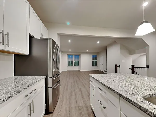 a kitchen with stainless steel appliances granite countertop a sink refrigerator and cabinets