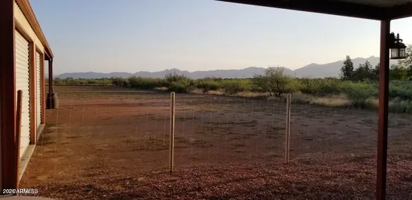 a view of backyard with wheel chair and iron fence