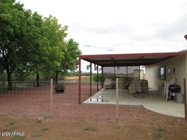 a backyard of a house with table and chairs