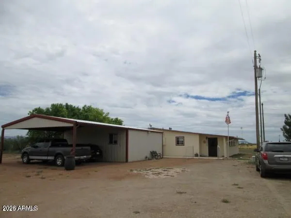 a view of house with car parked beside of it