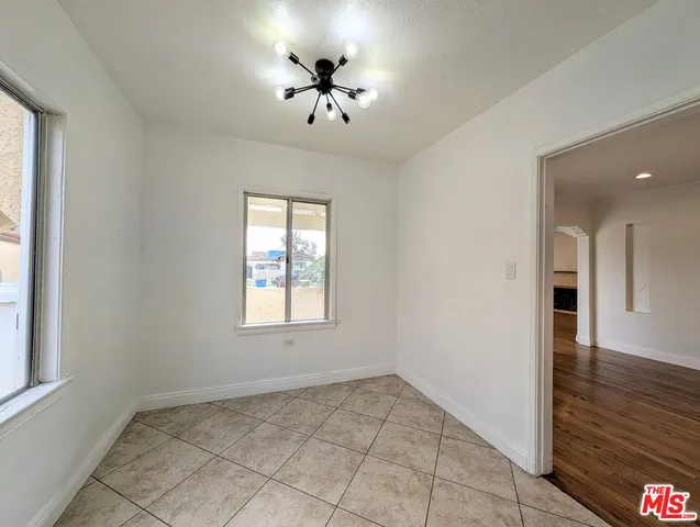 an empty room with wooden floor and chandelier fan