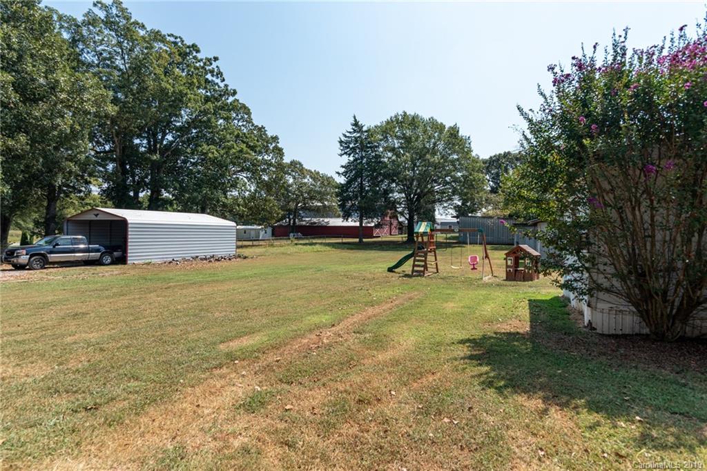 111 Flint Hill Road Cherryville, NC 28021 - Photo 8 of 24 a backyard of a house with a yard and large tree