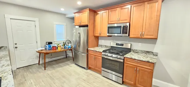a kitchen with stainless steel appliances granite countertop a stove a sink and a microwave