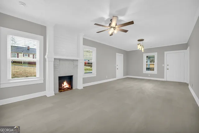 a view of an empty room with window and fireplace