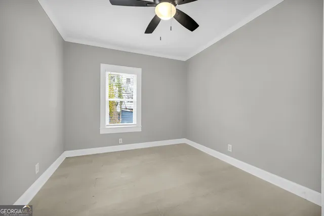 an empty room with closet and a chandelier fan