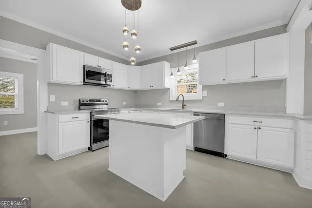 a kitchen with stainless steel appliances a white stove top oven and cabinets