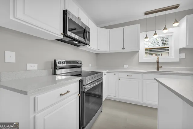a kitchen with a sink a stove and cabinets