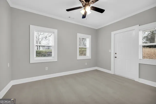 a view of a livingroom with a ceiling fan and window