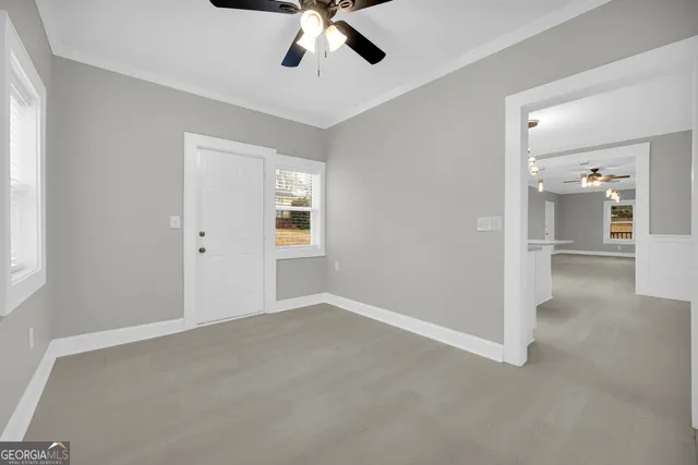 an empty room with chandelier fan