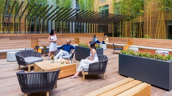 a view of a patio with couches table and chairs and a barbeque