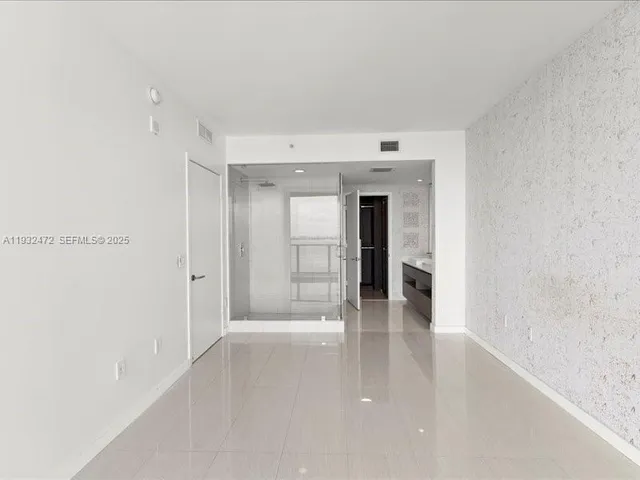 a view of a hallway with wooden floor and a kitchen
