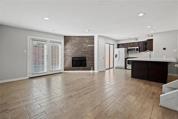 an empty room with wooden floor and fireplace