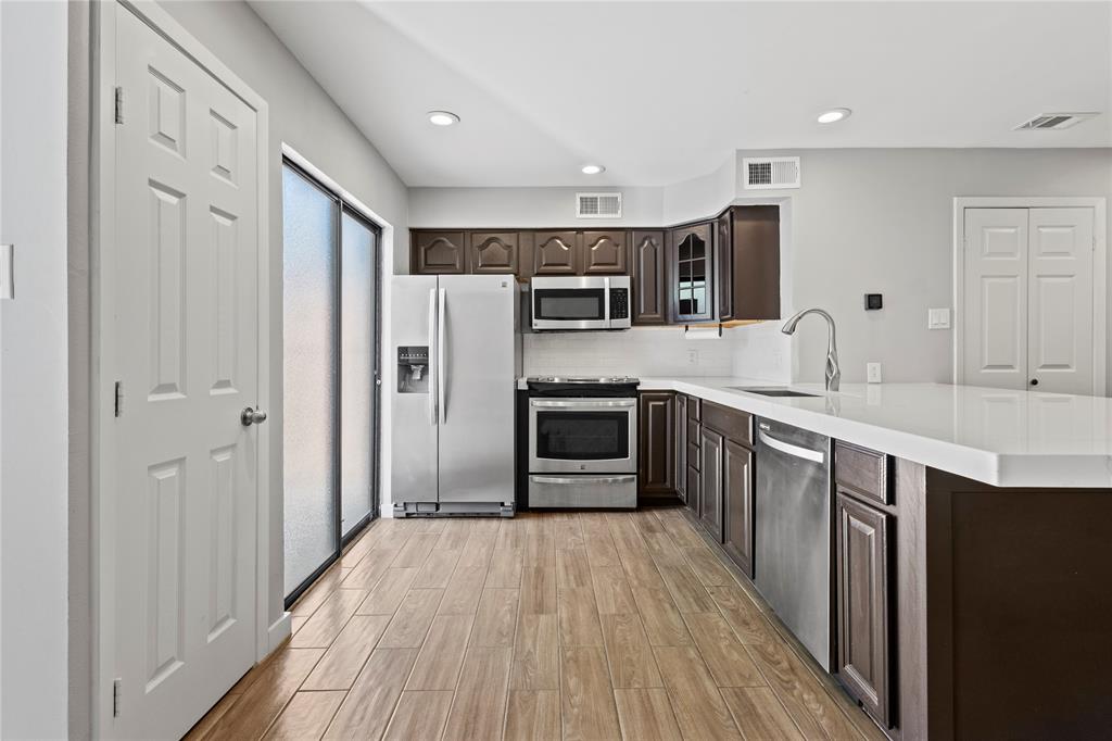 4371 Madera Road, Unit 4 Irving, TX 75038 - Photo 19 of 23 Kitchen featuring light hardwood / wood-style floors, stainless steel appliances, dark brown cabinets, backsplash, and sink