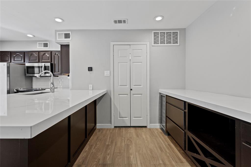 4371 Madera Road, Unit 4 Irving, TX 75038 - Photo 20 of 23 Kitchen featuring backsplash, dark brown cabinets, and light hardwood / wood-style floors