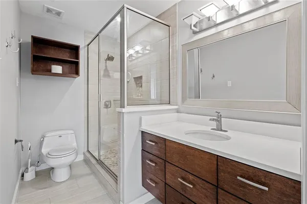 a bathroom with a sink a toilet and shower