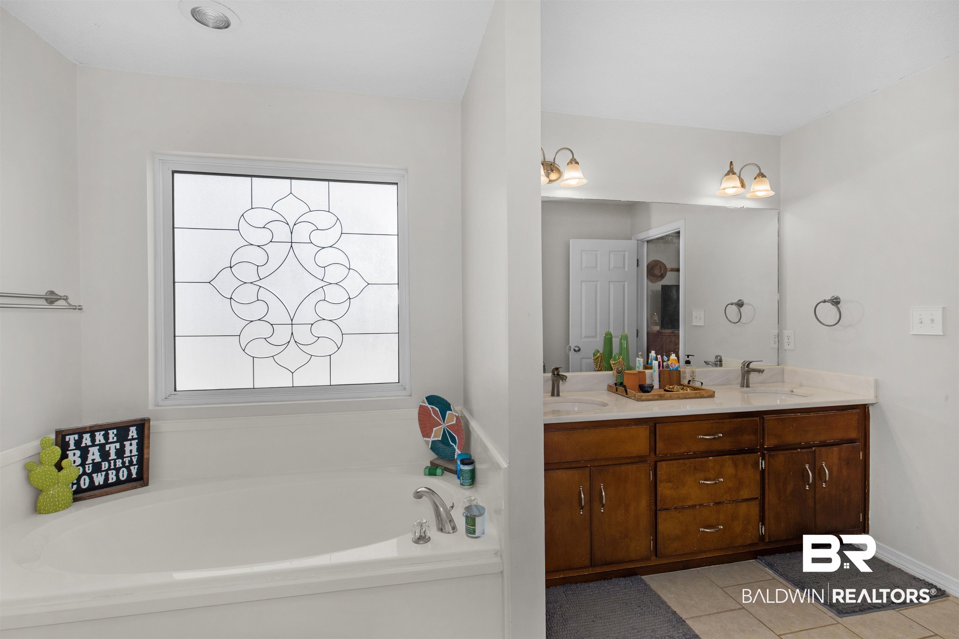 4950 Clealand Court Mobile, AL 36695 - Photo 12 of 20 Bathroom with double vanity, a sink, a bath, and tile patterned floors