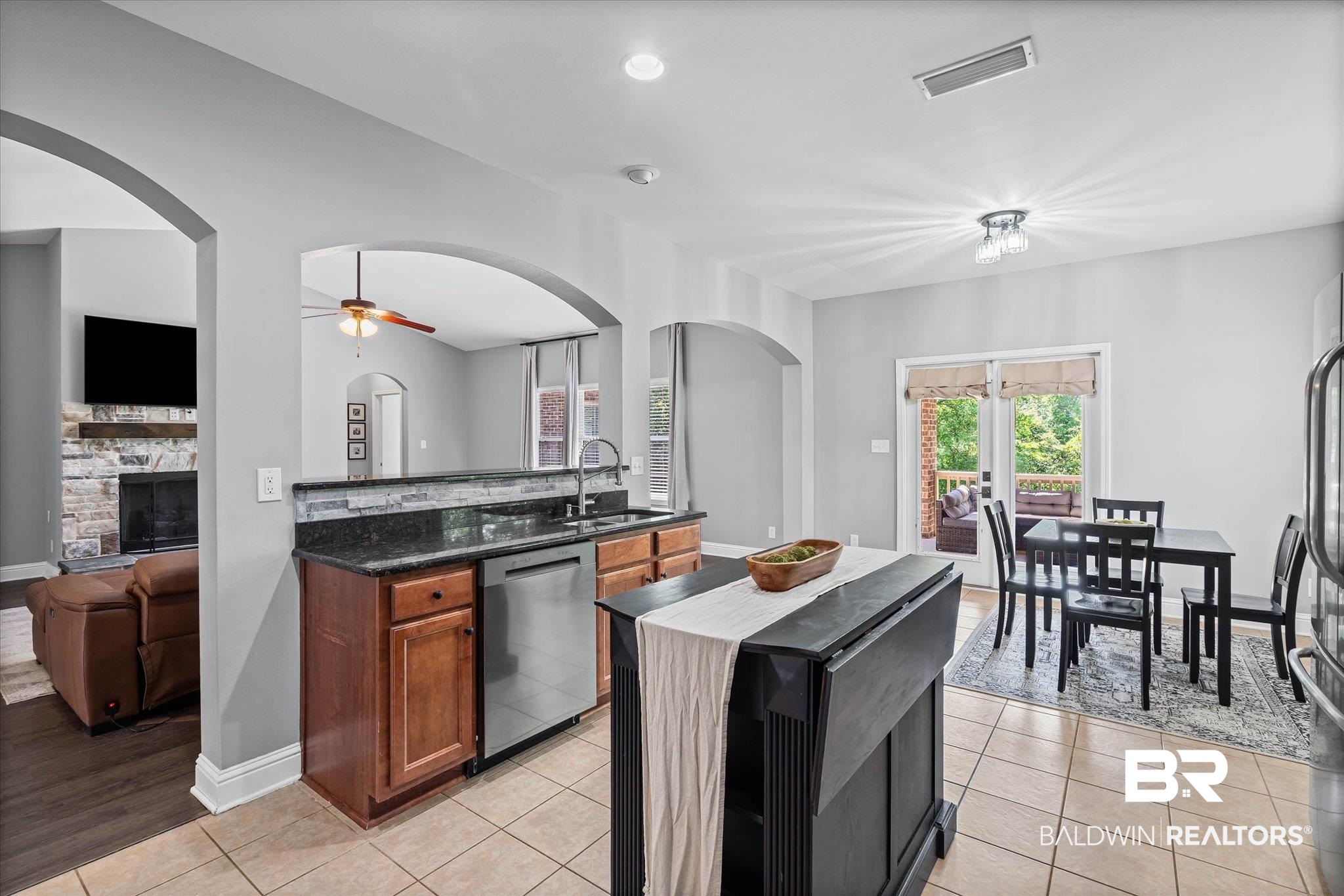 3739 Whitestone Drive Semmes, AL 36575 - Photo 9 of 25 Kitchen featuring tile flooring, granite countertops, a stainless steel dishwasher, and a stone backsplash