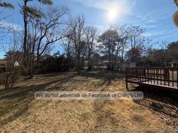 a view of house with backyard and trees