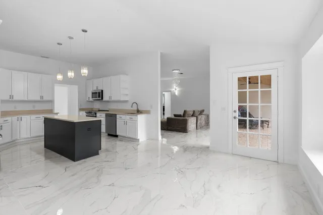 a kitchen with stainless steel appliances granite countertop a sink a stove and a refrigerator